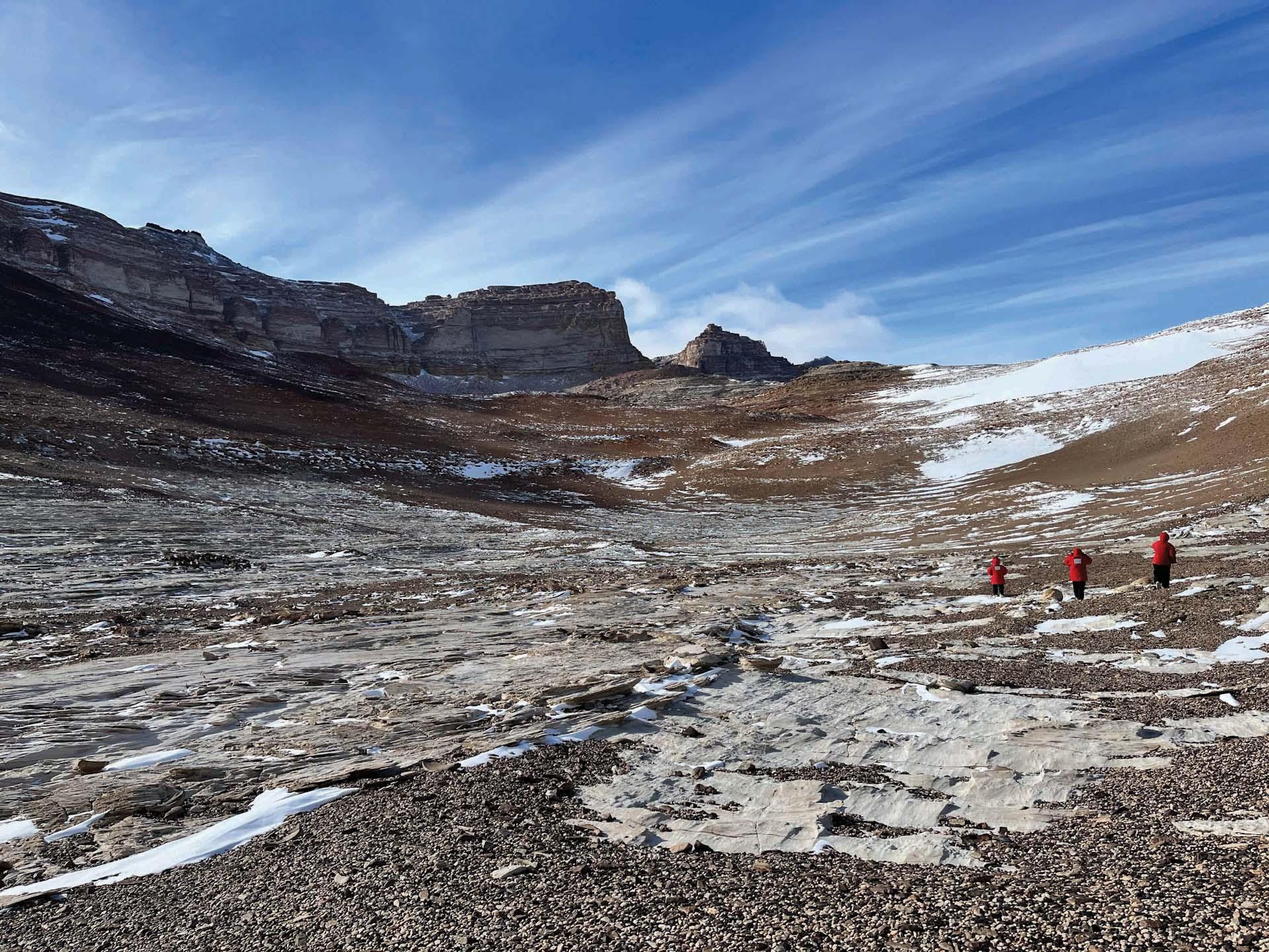 三位科学家在南极洲的岩石地带
