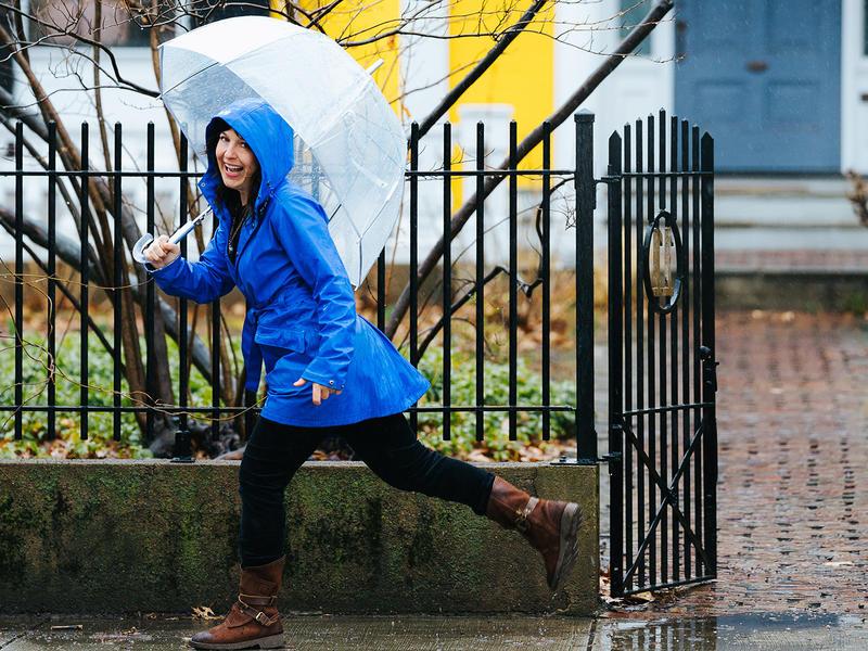 Sarah B. 米勒打着伞在雨中跳跃